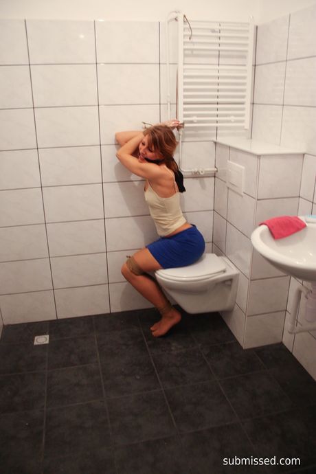 Brown-haired babe Eve is tied up and teased with a glass dildo