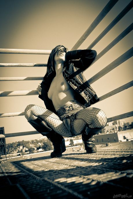 Den sexede amerikanske skønhed Joanna Angel viser sine bryster frem og poserer i en fishnet-bodystocking