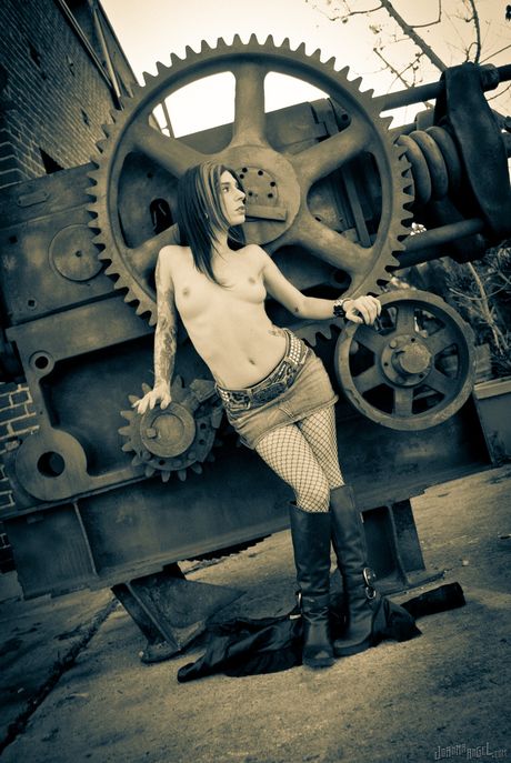 Joanna Angel i fiskenet og revne leggings poserer i industrielle omgivelser