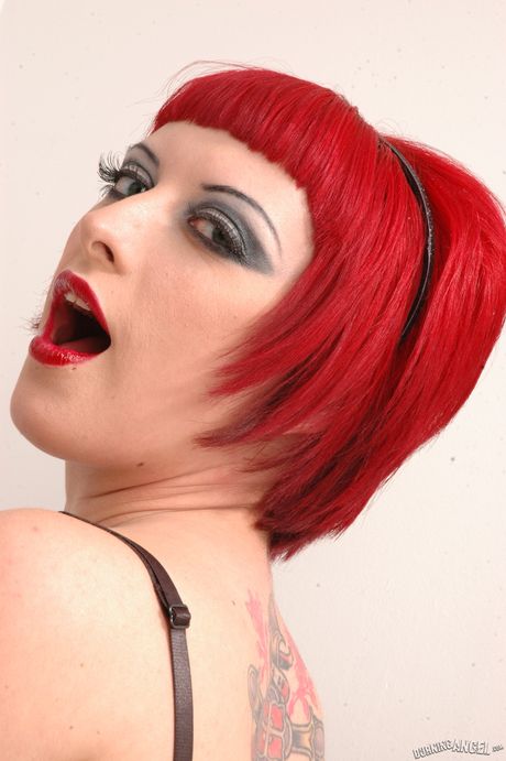 滿身刺青的美國紅髮美女 Jessie Lee 穿著漁網襪，秀出她迷人的胸部和臀部