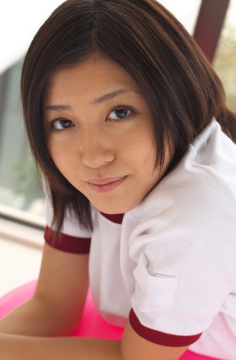 Den asiatiske pige Mami Matsuyama leger med en volleyball, mens hun har en sports-bh på