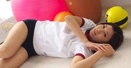 Den asiatiske pige Mami Matsuyama leger med en volleyball, mens hun har en sports-bh på