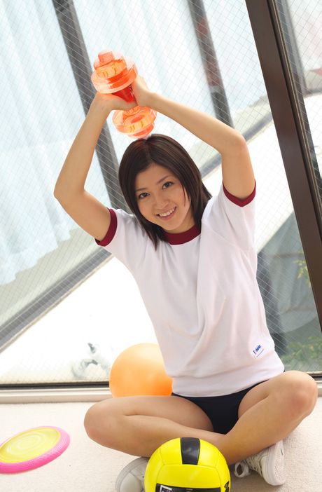 Den asiatiske pige Mami Matsuyama leger med en volleyball, mens hun har en sports-bh på