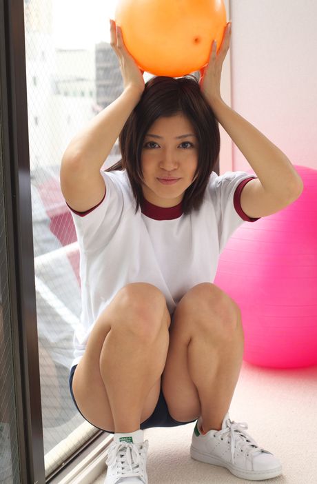 Den asiatiske pige Mami Matsuyama leger med en volleyball, mens hun har en sports-bh på