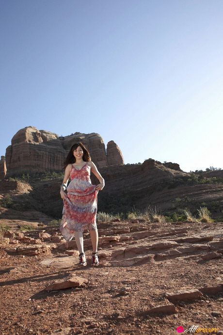 Asian beauty Yumi Sugimoto demonstrates her large boobs and her shaved pussy outdoors