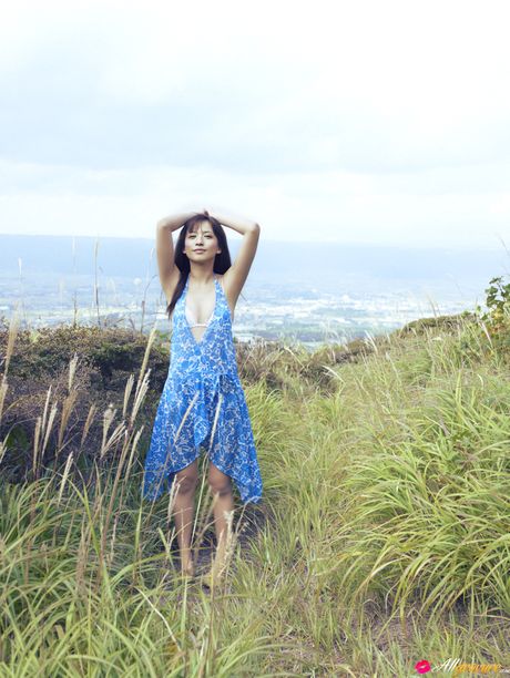 Asian chick Maomi Yuuki shows her small tits and offers her figure without clothing in the field