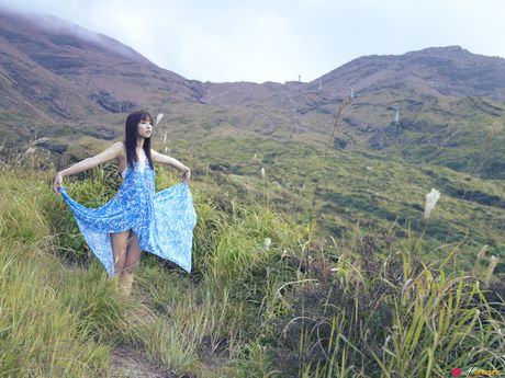 Asian chick Maomi Yuuki shows her small tits and offers her figure without clothing in the field