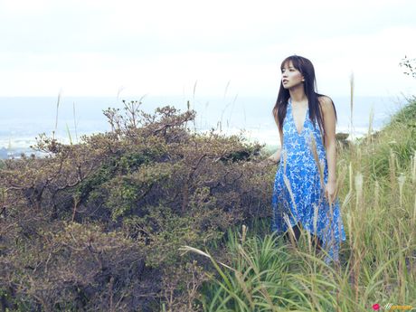 Asian chick Maomi Yuuki shows her small tits and offers her figure without clothing in the field