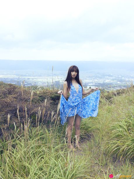 Asian chick Maomi Yuuki shows her small tits and offers her figure without clothing in the field