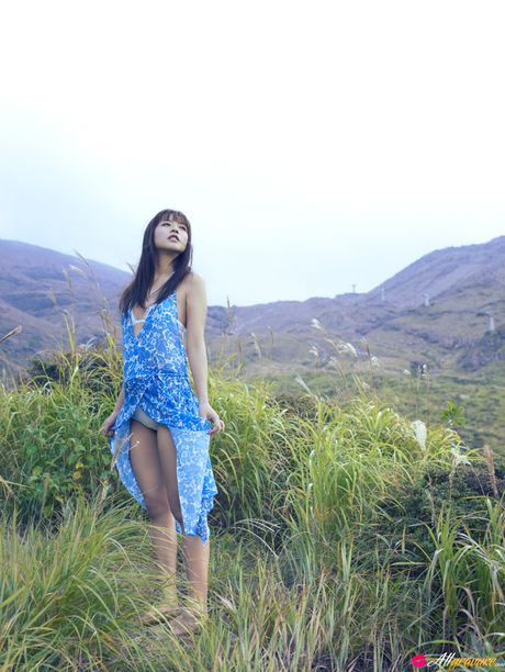 Asian chick Maomi Yuuki shows her small tits and offers her figure without clothing in the field