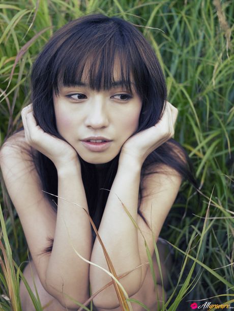 Asian chick Maomi Yuuki shows her small tits and offers her figure without clothing in the field