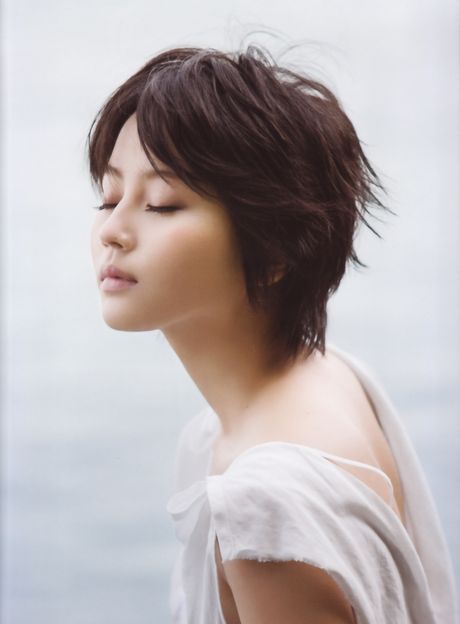 アジア人の女の子、堀北真希が帽子とロングコートを着て裸になる