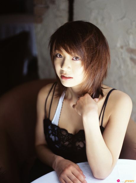 亞洲熟女 Hitomi Aizawa 展示她令人驚嘆的乳房並穿著白色絲襪擺姿勢