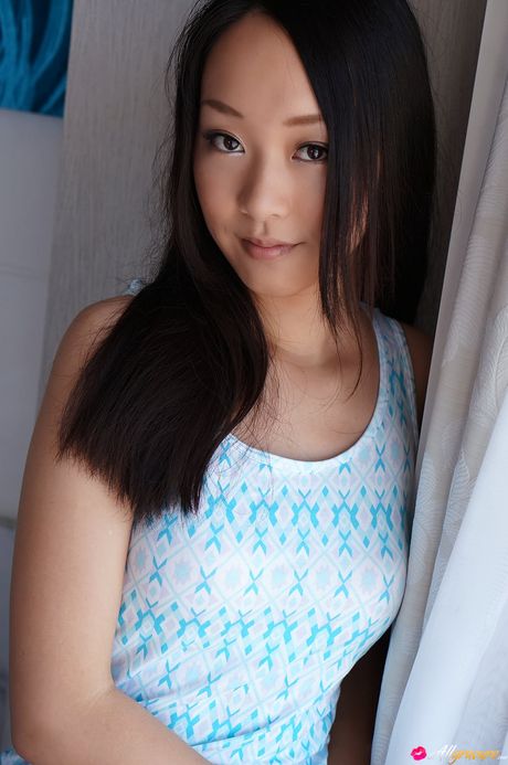 Den asiatiske dukke Nao Ogawa tager sit lingeri af og tilbyder sin figur uden tøj på sengen