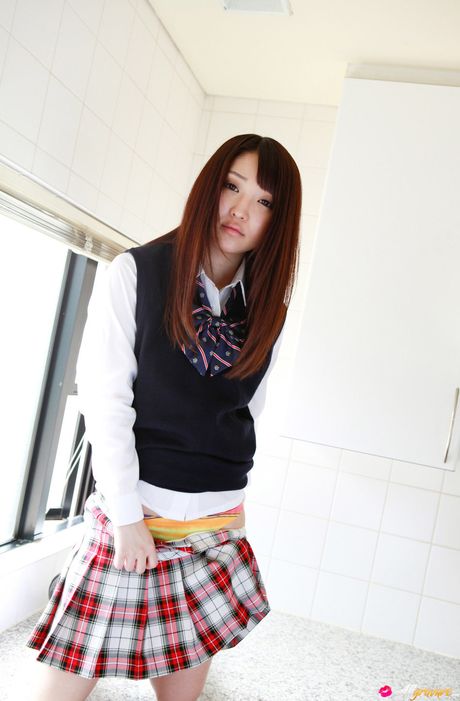 Asiatisk pige Yoshiko Suenaga bliver nøgen på en gynge i en skolepigeuniform