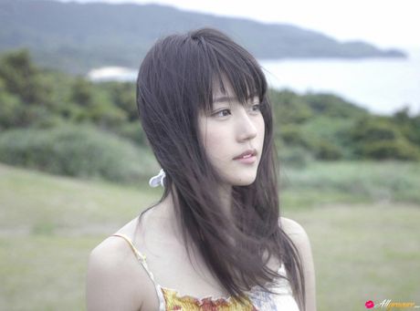 Asiatisk teenager Asumi Arimura bliver nøgen i en mark med vilde blomster