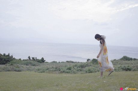 Asiatisk teenager Asumi Arimura bliver nøgen i en mark med vilde blomster