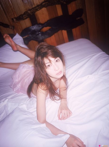 Asiatisk teenager Emi Kobayashi bliver nøgen på sin seng i hæle