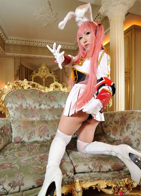 Asian teen Saku wears a pink wig and gloves while modelling in a hall
