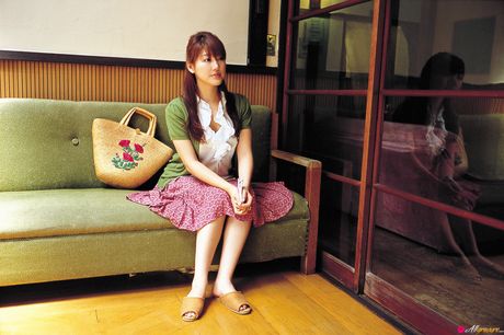 茶色の目をした日本の美人、安めぐみがセクシーな衣装で屋外でポーズをとっている