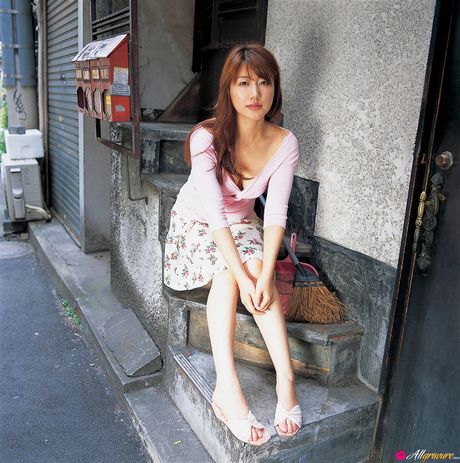 茶色の目をした日本の美人、安めぐみがセクシーな衣装で屋外でポーズをとっている