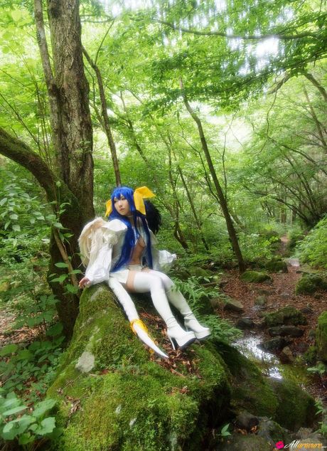 アジアの十代のアヤカは青い髪で森の中でロングドレスを着こなす