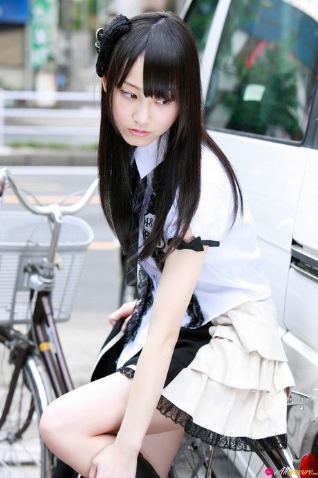 Dark haired teen Rena Matsui gets naked on a bicycle in a school uniform