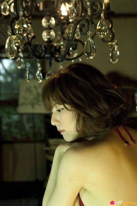 アジア人モデルの杉本有美が、その巨大な胸を披露し、赤いビキニでポーズをとる