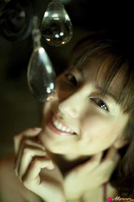 アジア人モデルの杉本有美が、その巨大な胸を披露し、赤いビキニでポーズをとる