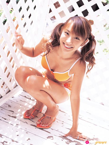 Hun poserer på stolen og lænestolen og smiler bredt