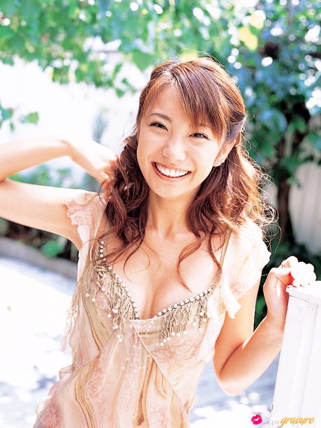 Hun poserer på stolen og lænestolen og smiler bredt