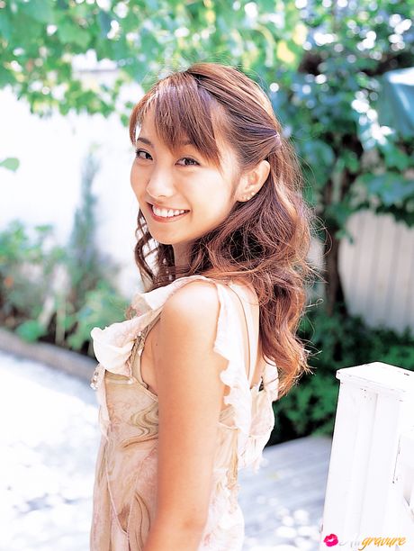 Hun poserer på stolen og lænestolen og smiler bredt