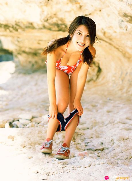 Asian teen Emi Kobayashi gets naked on a blanket in a bikini