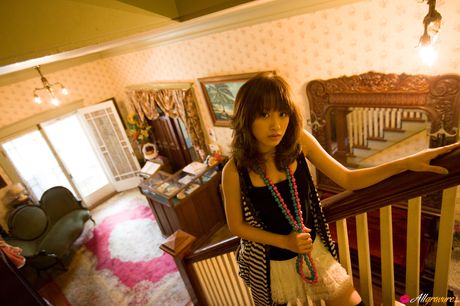 Asiatisk skønhed Ai Takahashi modellerer en sort kjole og strømper