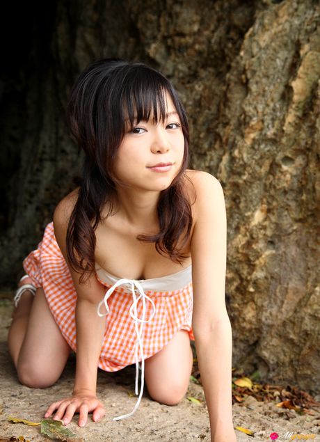 亞洲女孩 Mana 在海灘上展示她迷人的胸部並穿著比基尼擺姿勢