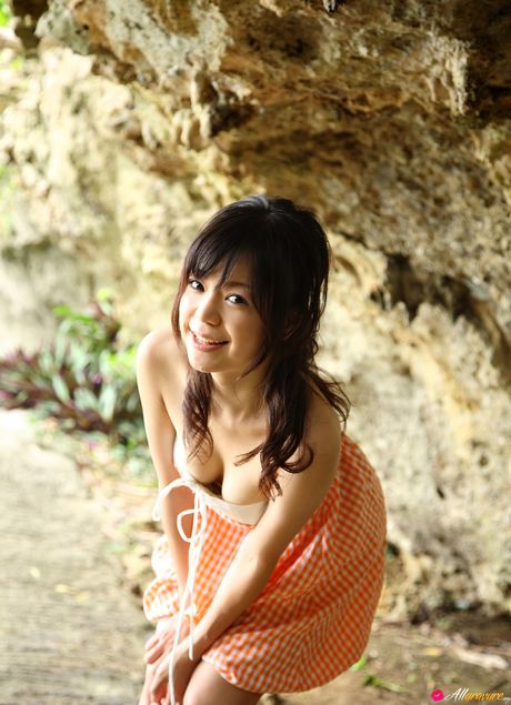 亞洲女孩 Mana 在海灘上展示她迷人的胸部並穿著比基尼擺姿勢