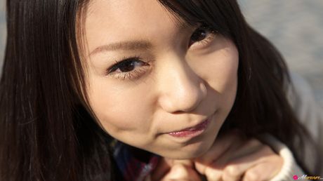 Asian schoolgirl Tomoyo Hoshino displays her tits and poses in stockings