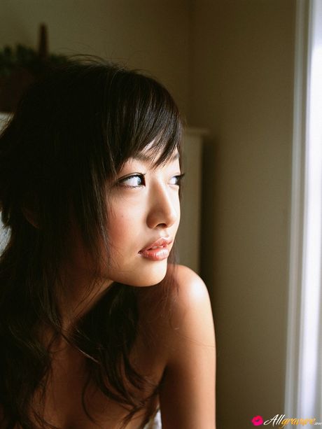 Asian teen Risa Kudo demonstrates her nice tits and poses in a red dress