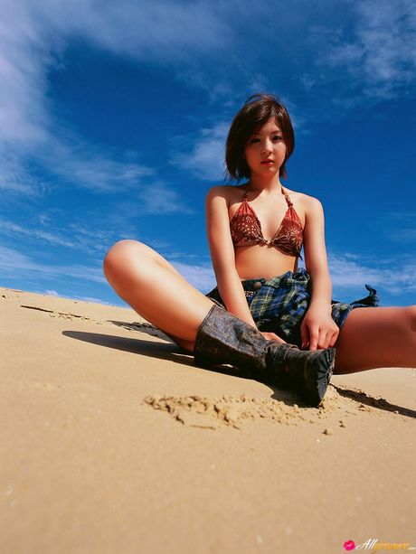 Asian doll Rina Nagasaki gets naked on a blanket on a sandy beach