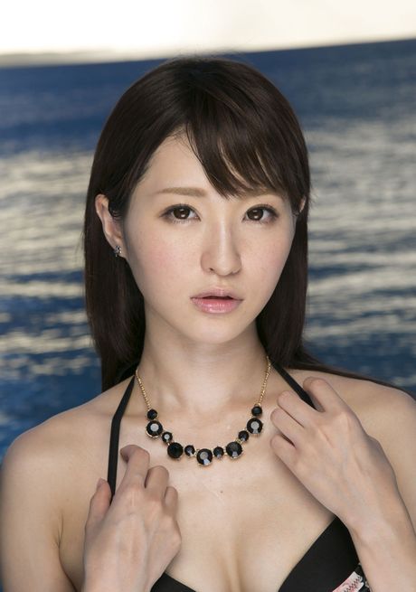 Asiatisk pige Angel Moe bliver nøgen på et tæppe på en sandstrand