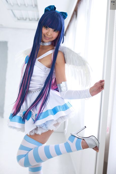 彼女は裸で、ストッキングとハイヒールを履いて床にポーズをとっている