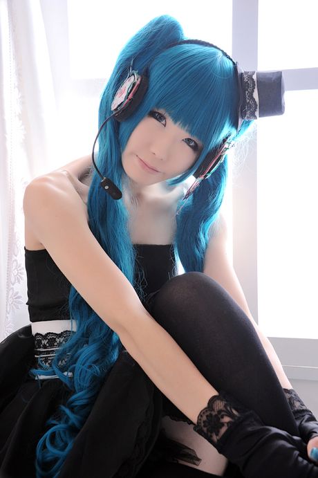 Asian stunner Haruka models a black dress and gloves in a masquerade