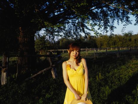 Asiatisk teenager Konno Asami bliver nøgen i et felt med vilde blomster