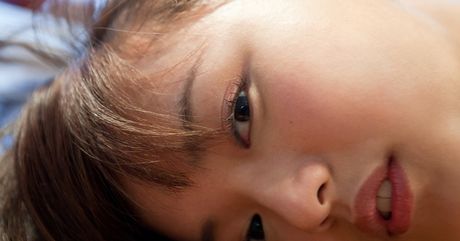 Den asiatiske covergirl Mayumi Yamanaka bliver nøgen på sengen i sorte strømper