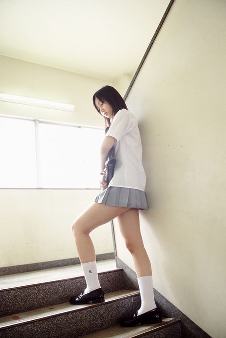 Asiatisk søde Risa Yoshiki bliver nøgen på en balkon i en skolepigeuniform