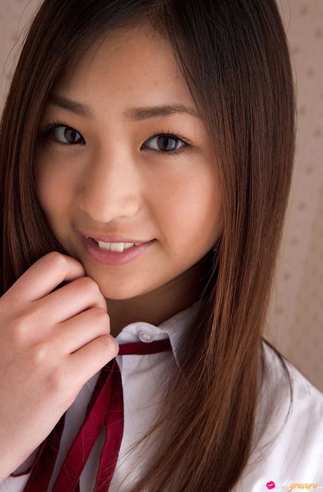 Asian cutie Ayaka Sayama gets naked on a bed in a pleated skirt