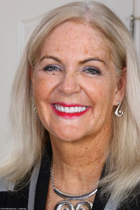 Moden blondine Judy Mayflower viser sine store bryster og spreder sin fisse