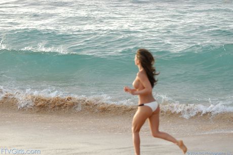 Dark-haired solo girl Isabella Camille removes her bikini to get naked on a beach