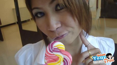 Asiatisk covergirl amatørpige sutter en slikkepind, før hun spiser sin egen fisse