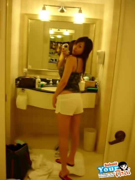 Asiatisk babe amatørpige bliver nøgen i en sort kjole og hæle